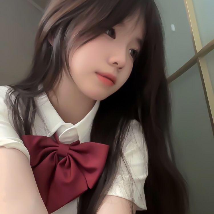 Cô gái trẻ mặc đồng phục trắng với nơ đỏ trong ánh sáng mềm mại