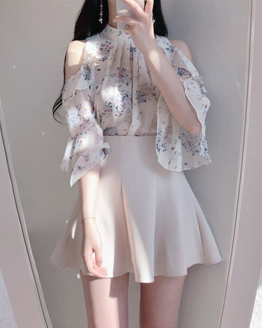 Cô gái xinh mặc áo blouse hoa và chân váy ngắn chụp ảnh vui vẻ