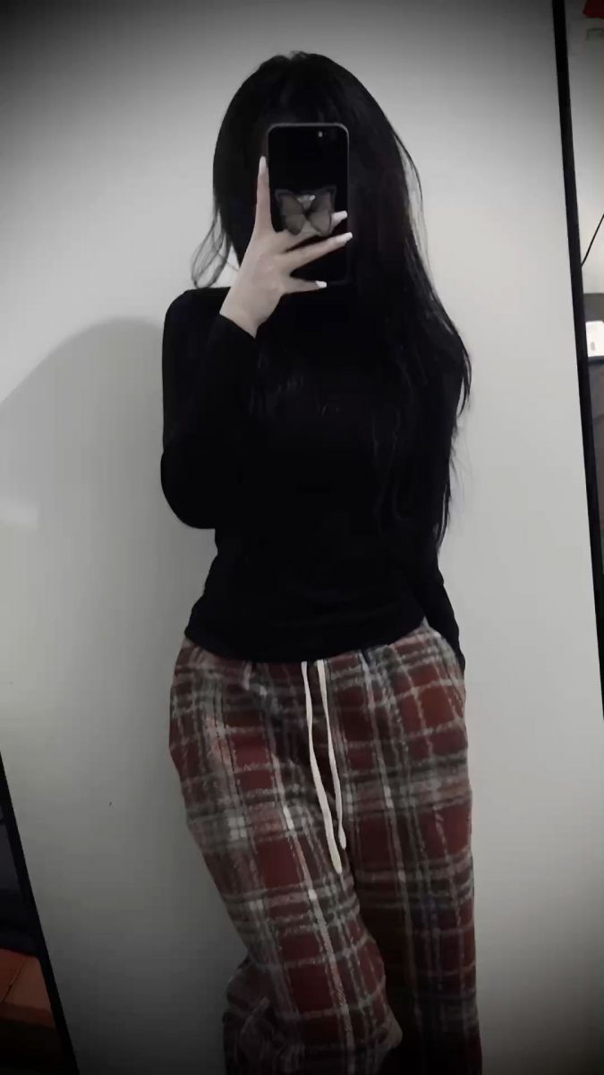 Cô gái xinh mặc áo đen và quần sọc caro chụp selfie tự tin