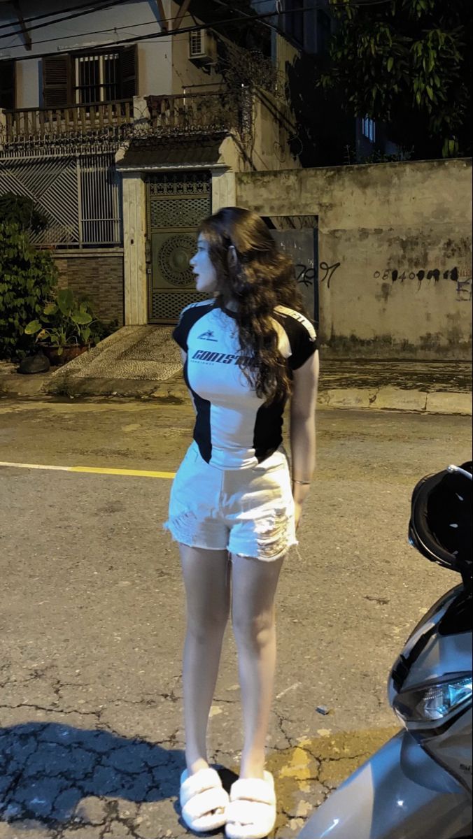 Cô gái xinh mặc áo phông trắng, quần short đen dạo phố