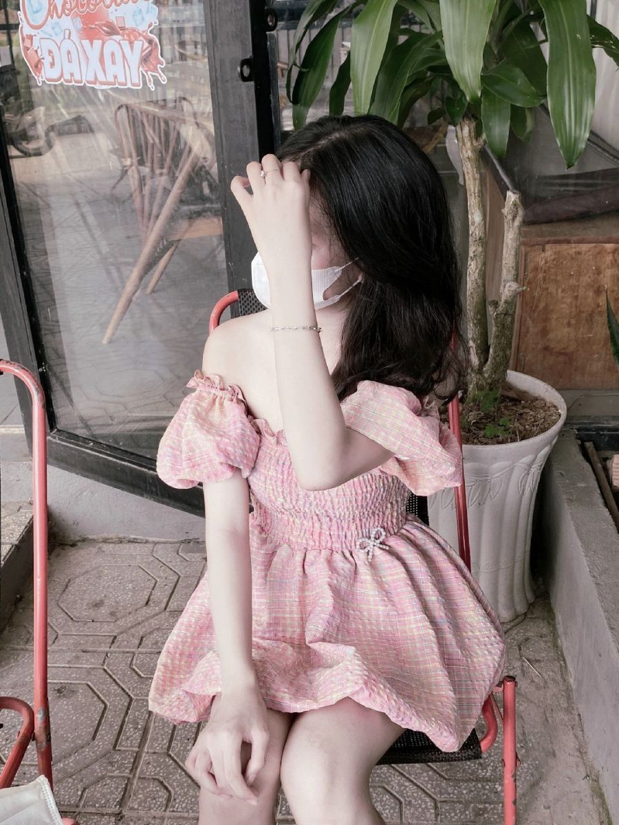 Gái che mặt trong bộ đồ hồng dễ thương tại quán cà phê