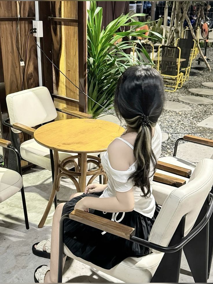 Gái đẹp mặc áo trắng, chân váy đen bên bàn tròn