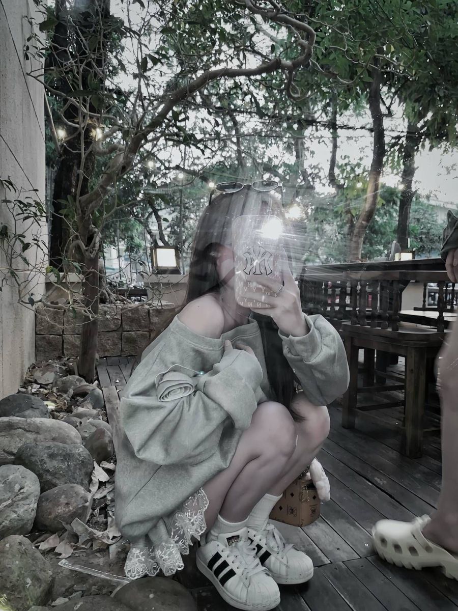 Gái trẻ mặc áo sweatshirt xám chụp ảnh selfie tại quán cà phê
