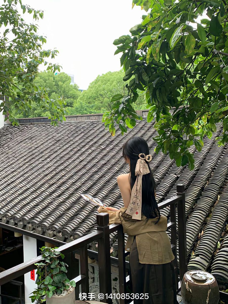 Gái xinh diện áo hai dây, quần dài trên ban công