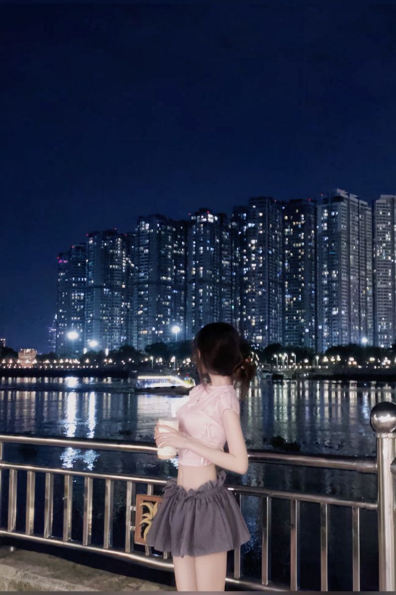 Gái xinh mặc áo crop top hồng và chân váy xòe bên cầu Cẩm Cóc