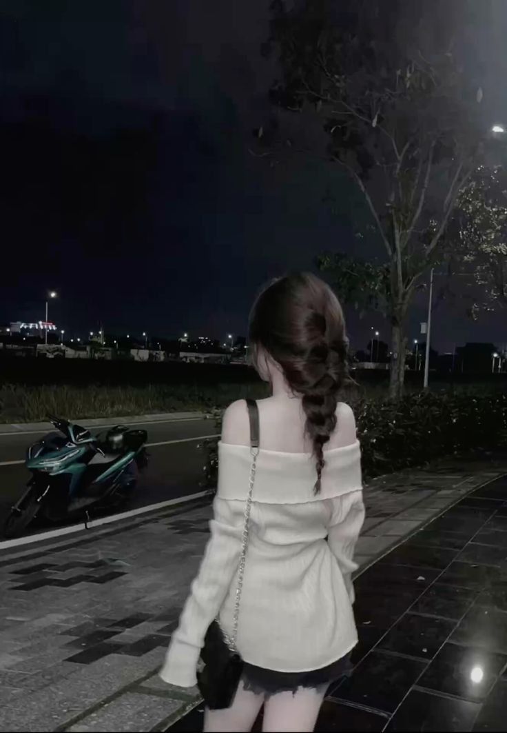 Gái xinh mặc áo len off-shoulder và chân váy ngắn bên xe máy