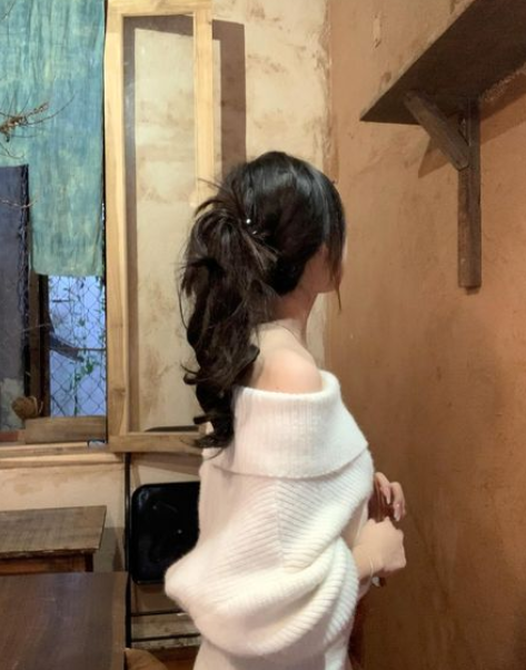 Gái xinh mặc áo len trắng off-shoulder trong quán cà phê