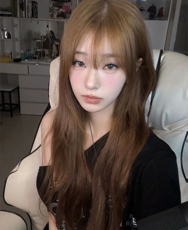 Gái xinh mặc áo thun đen ngồi trên ghế gaming