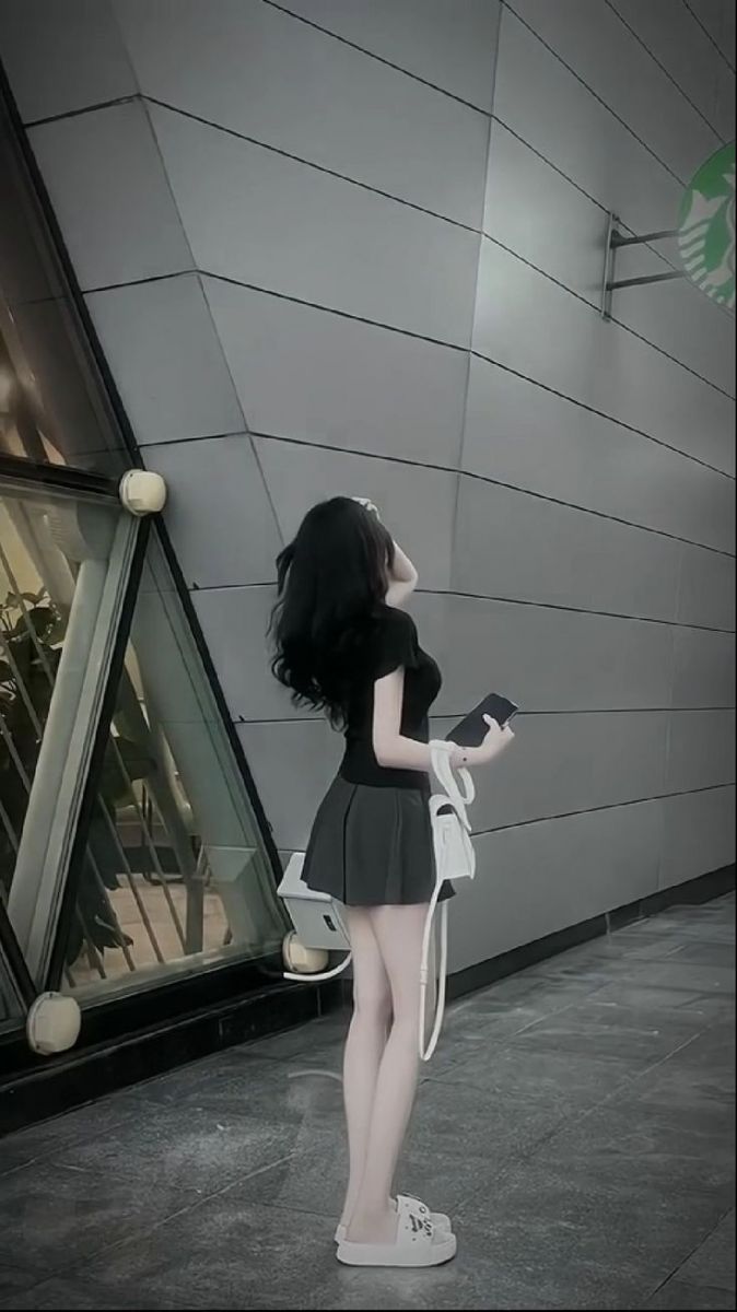 Gái xinh mặc áo thun đen và chân váy ngắn