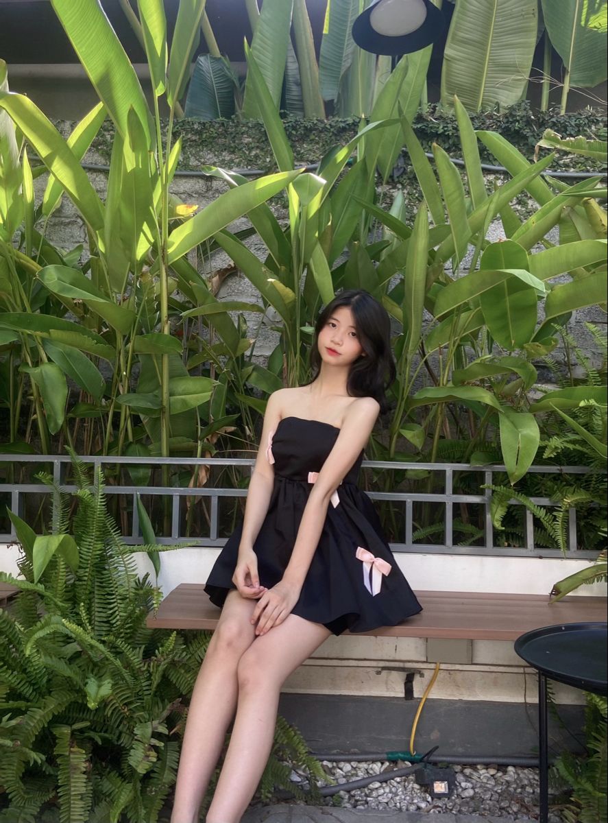 Gái xinh mặc đầm đen ngồi giữa không gian xanh mát