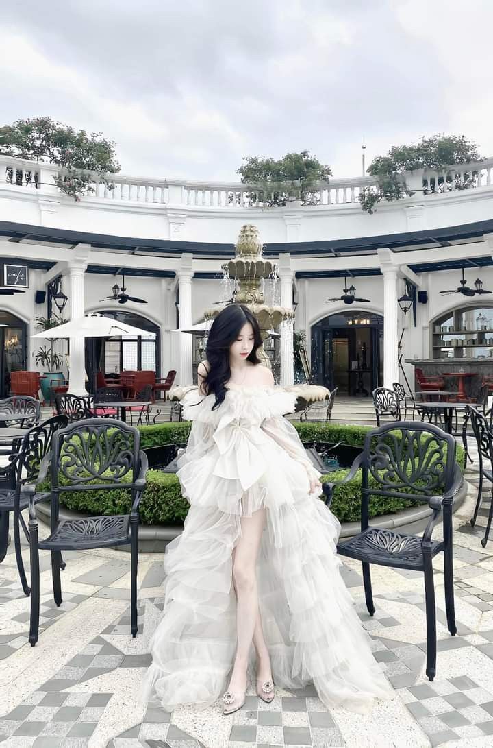Gái xinh mặc váy trắng lộng lẫy bên đài phun nước