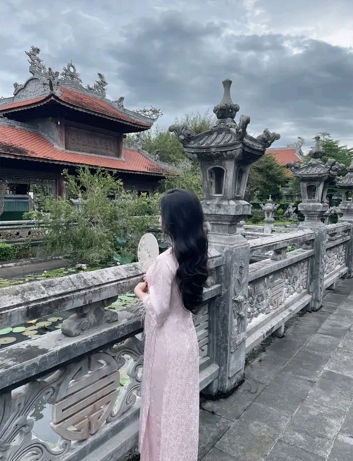 Gái xinh trong áo dài hồng bên lan can thơ mộng