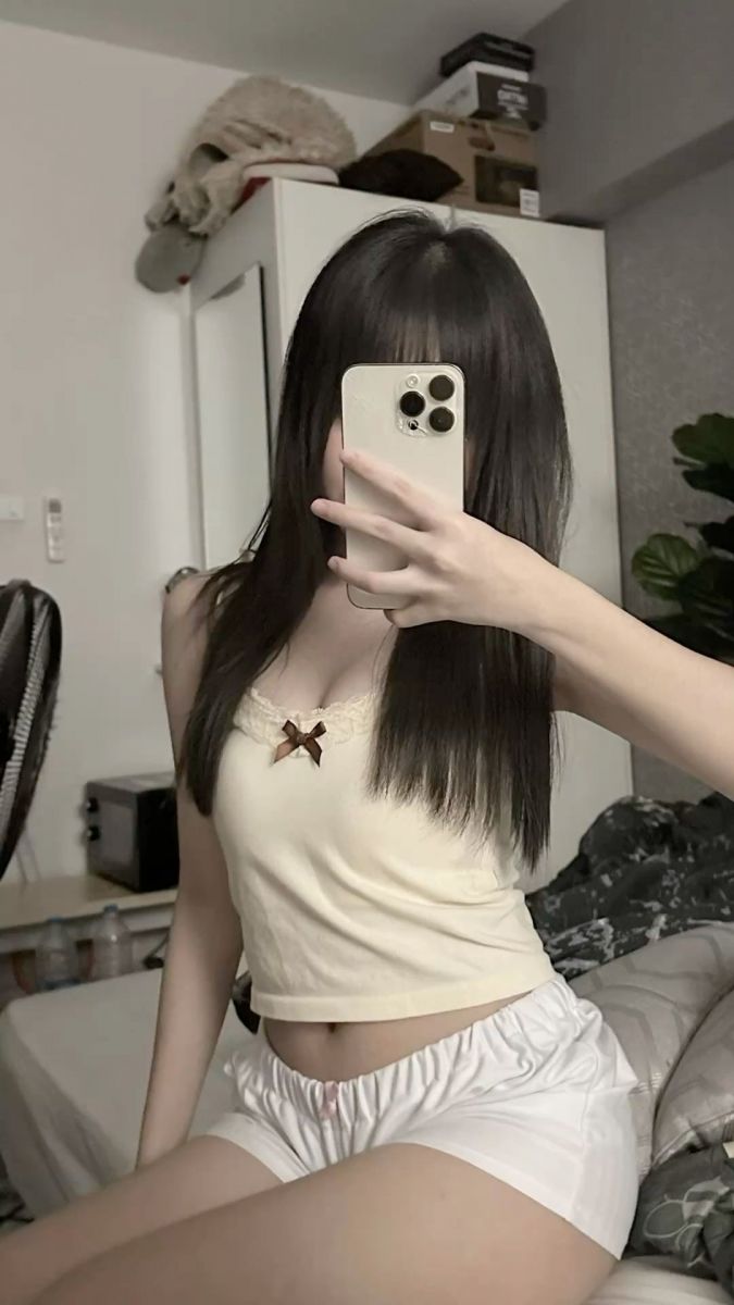 Gái xinh trong áo thun trắng và quần short chụp ảnh selfie