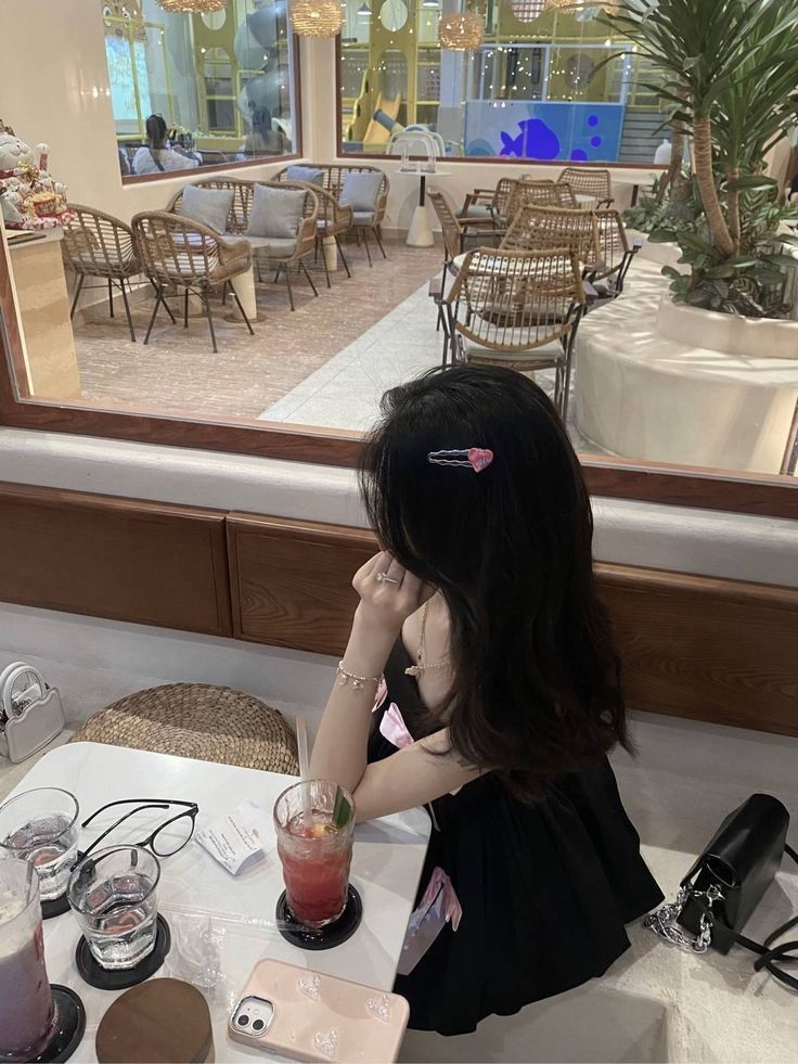 Gái xinh trong đầm đen ngồi quán cà phê nhìn ra cửa sổ