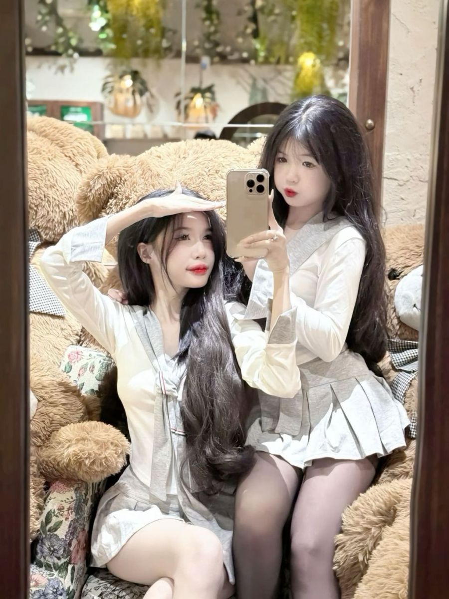 Hai cô gái trẻ trong đồng phục học sinh chụp ảnh selfie dễ thương