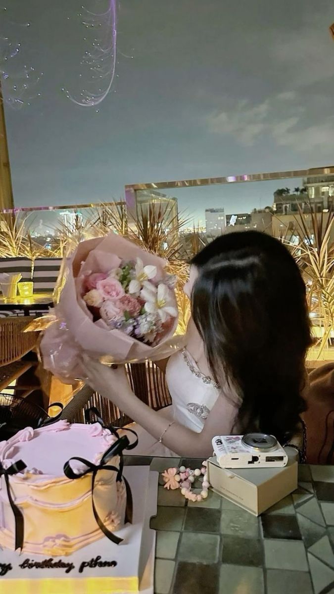 Người phụ nữ mặc áo sát nách trắng nổi bật trong tiệc sinh nhật