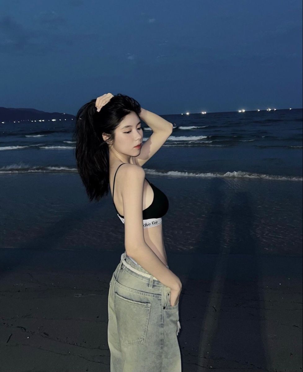 Gái: Cô Gái Trẻ Mặc Áo Crop Top Đen Và Quần Jeans Sáng Màu Bên Bờ Biển