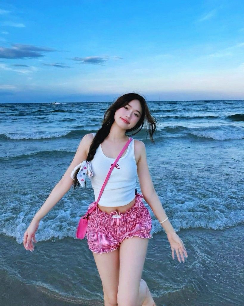 Ảnh gái trẻ mặc áo sát nách trắng và quần sooc kẻ caro đỏ