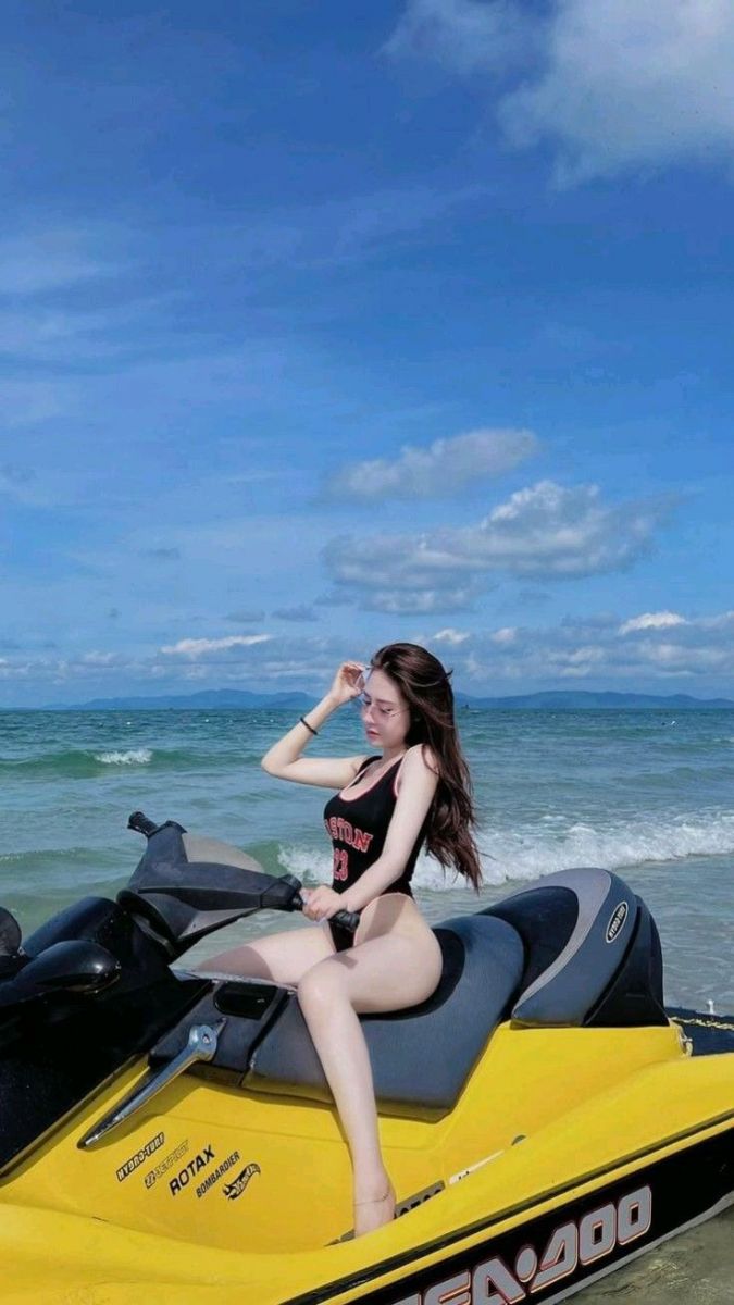 Ảnh gái trẻ mặc áo tắm đen ngồi trên xe máy màu vàng