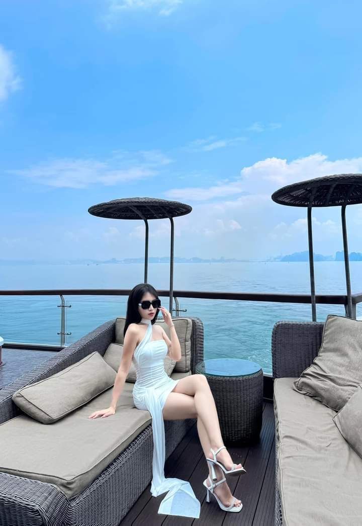 Ảnh gái trẻ mặc váy trắng ngồi trên ghế sofa nhựa