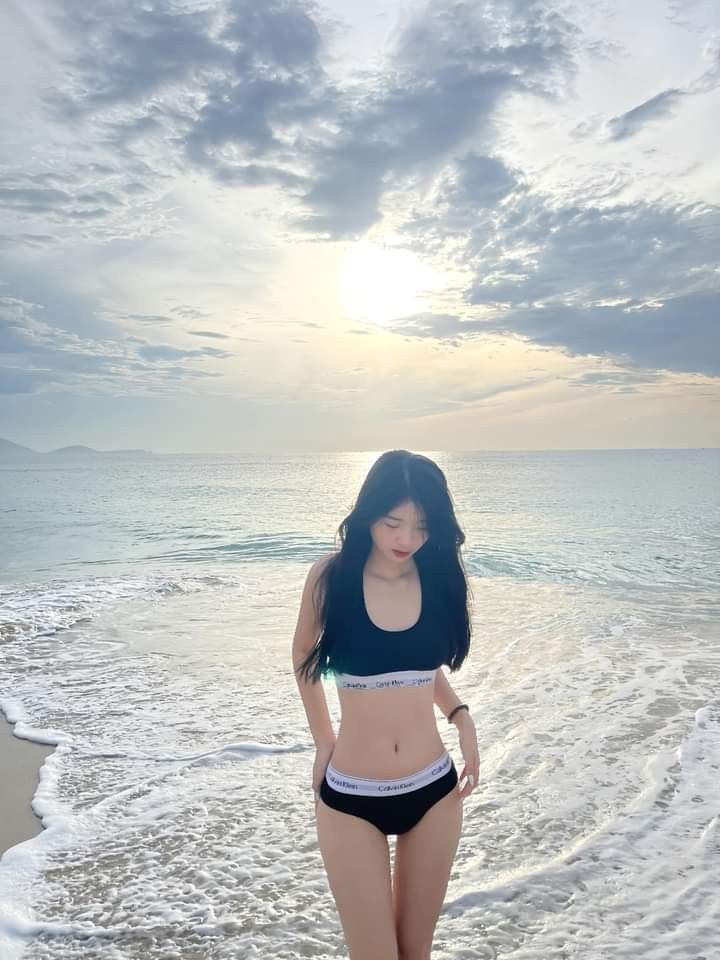 Cô gái mặc bikini đen bên bờ biển tuyệt đẹp