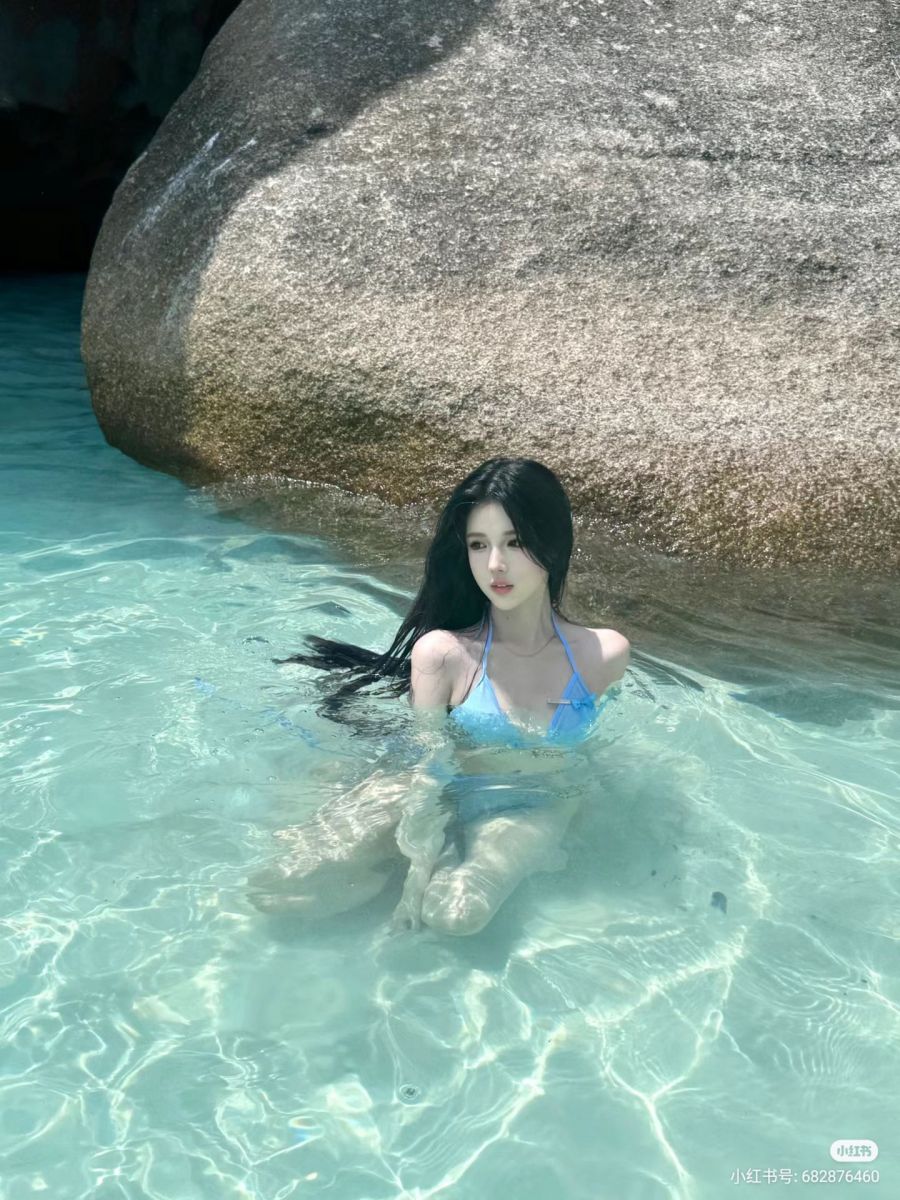 Cô gái mặc bikini màu xanh thư giãn giữa những tảng đá lớn