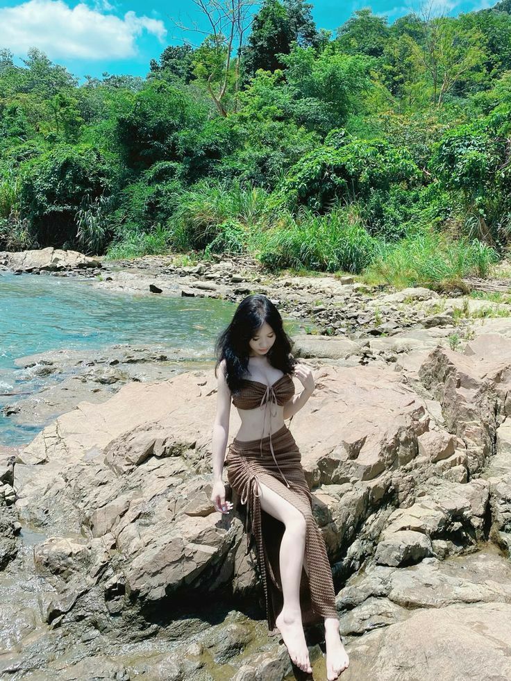 Cô gái mặc bikini nâu tạo dáng tự tin bên bờ sông