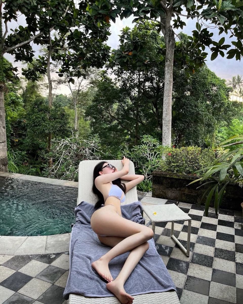 Cô gái mặc bikini thư giãn bên bể bơi xanh mát