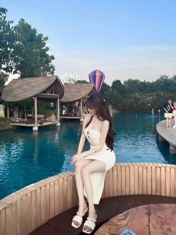 Cô gái trẻ mặc đầm trắng gợi cảm bên Hồ Tây