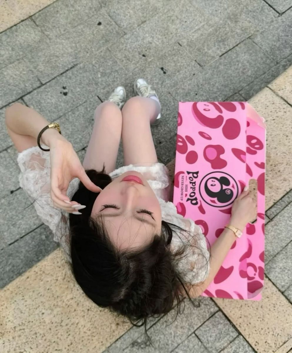 Cô gái trẻ mặc váy trắng ngồi trên nền gạch cam