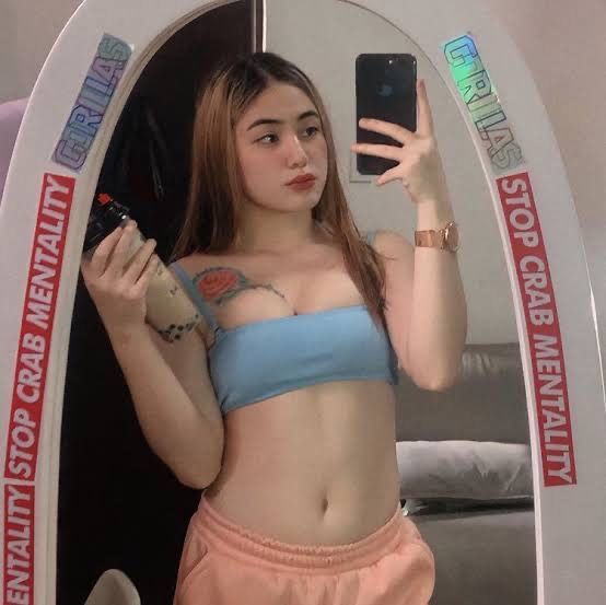 Cô gái trẻ trong áo crop top xanh và quần short hồng