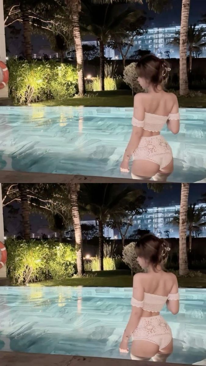 Cô gái xinh đẹp trong áo crop top và quần short trắng bên hồ bơi