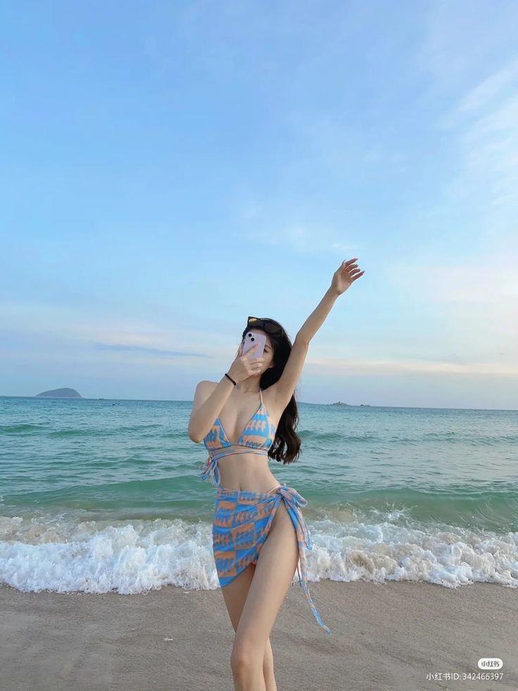 Cô gái xinh đẹp trong bikini màu xanh và trắng bên bờ biển