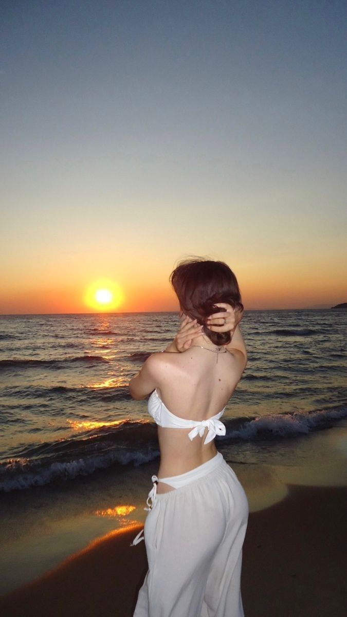 Cô gái xinh đẹp trong bộ bikini trắng bên bờ biển