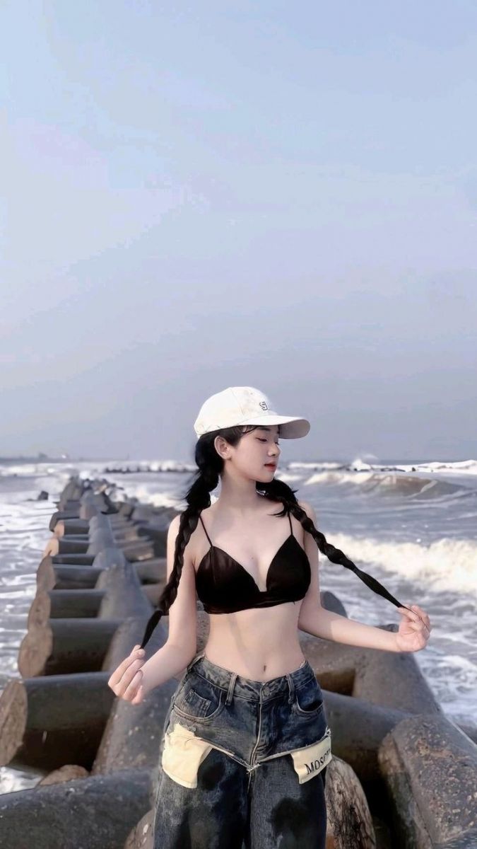 Cô gái xinh đẹp với áo bra màu đen và quần jeans rông