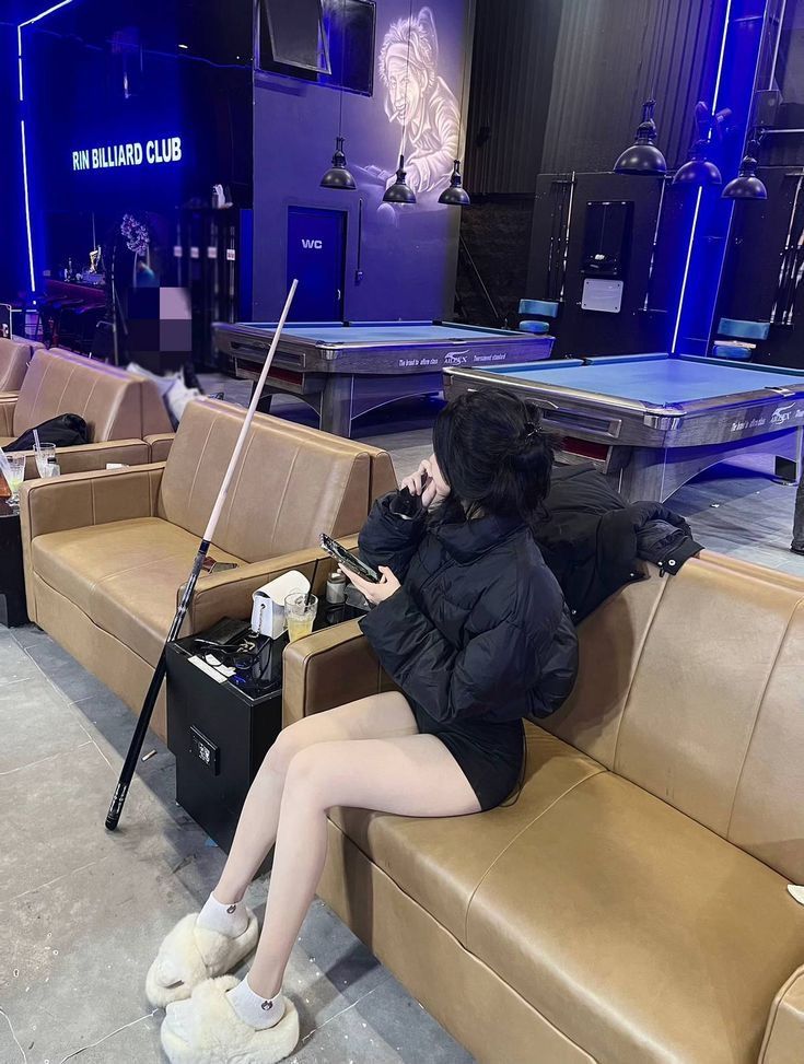 Gái đẹp mặc váy ngắn và áo khoác ấm tại quán billiard