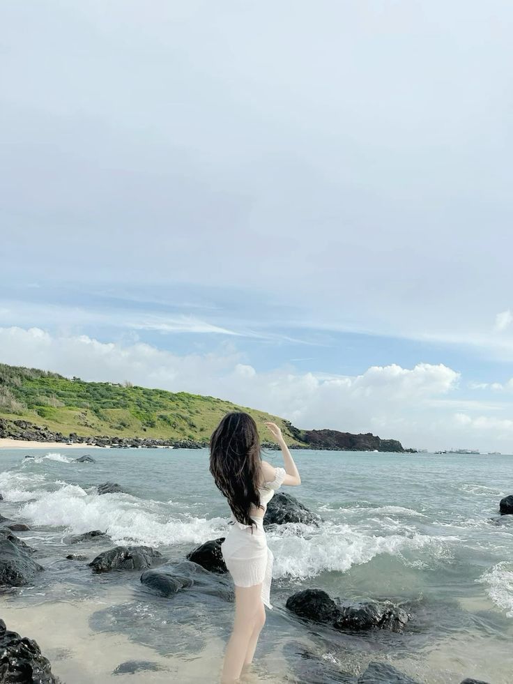 Gái trẻ mặc váy trắng bên bờ biển
