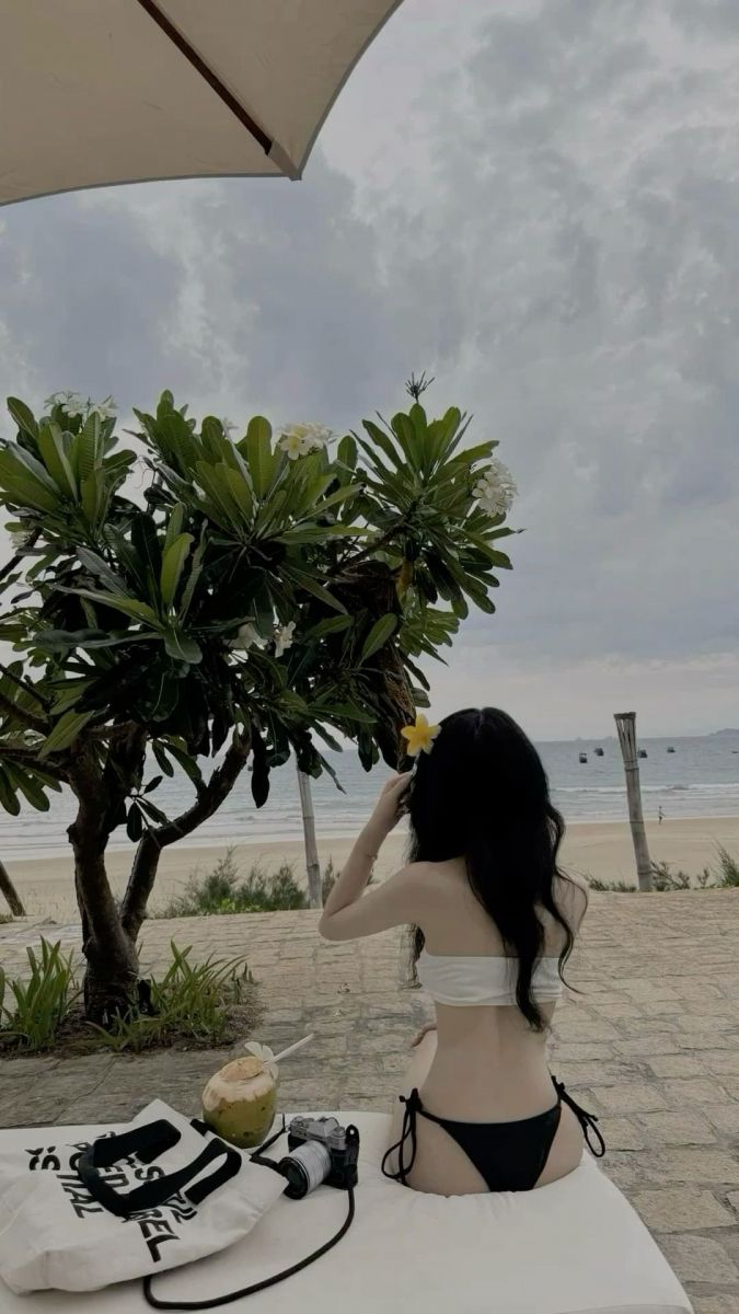 Gái xinh mặc bikini ngồi bên cây dừa