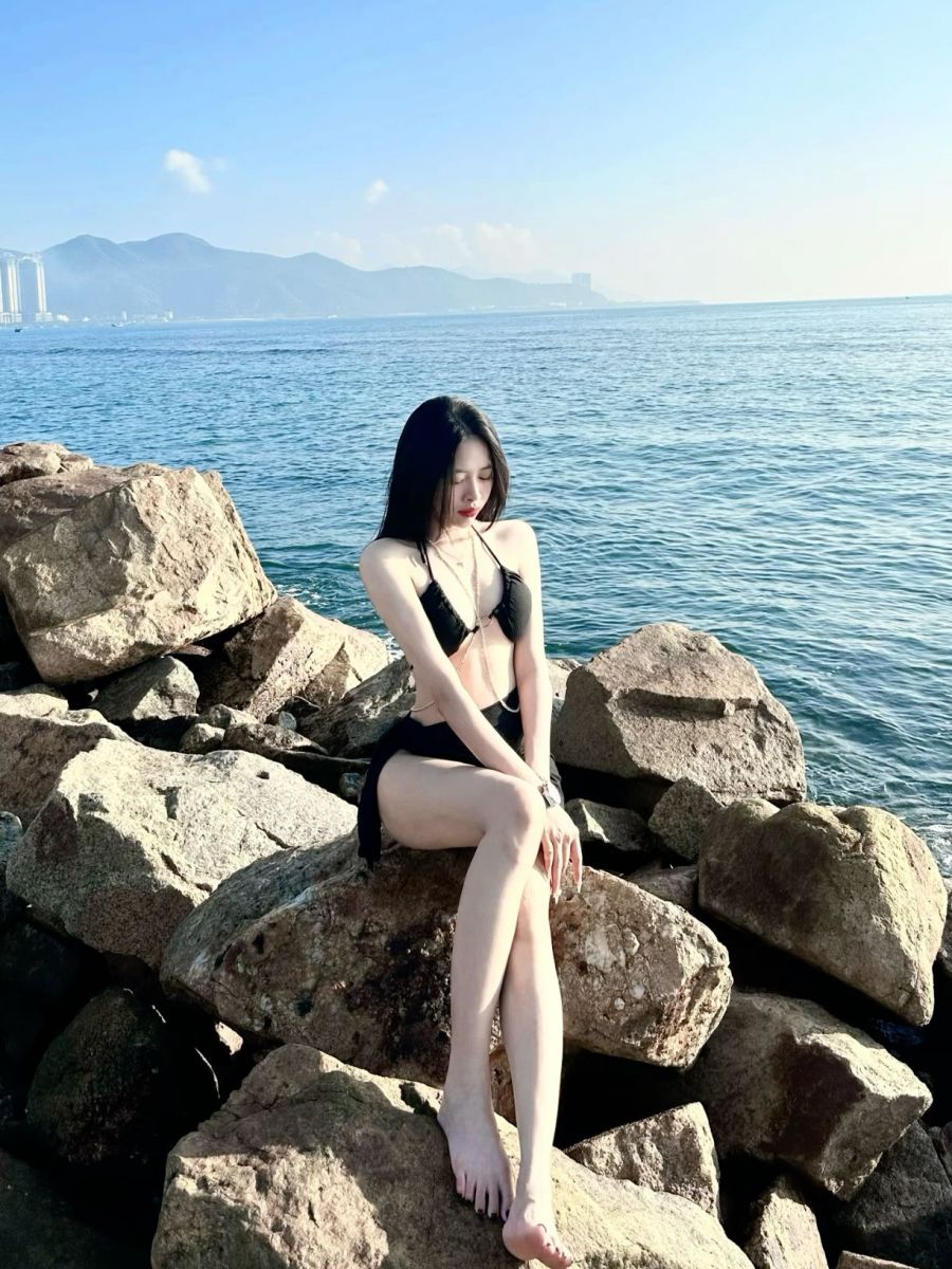 Nữ mặc bikini đen tự tin bên bờ biển