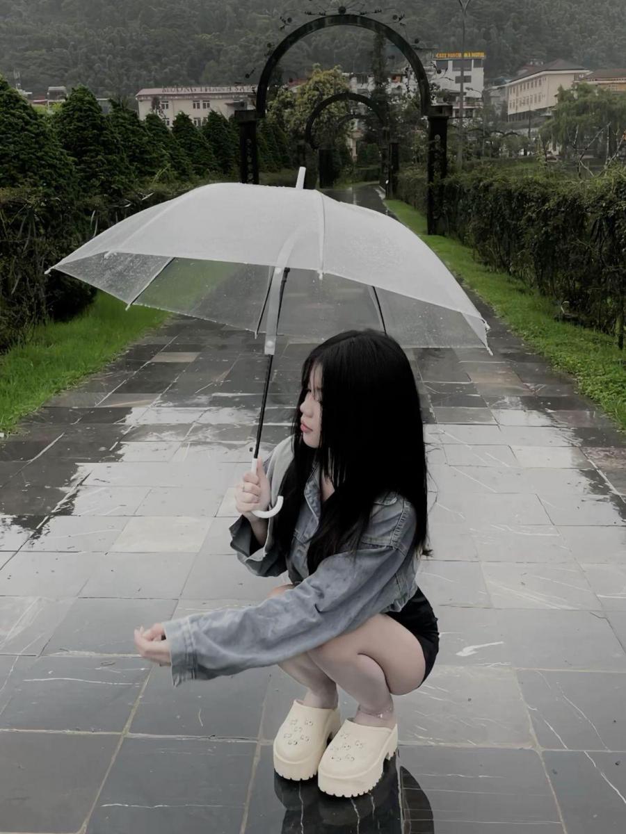 Gái xinh ở chuồng với chiếc ô trong mưa