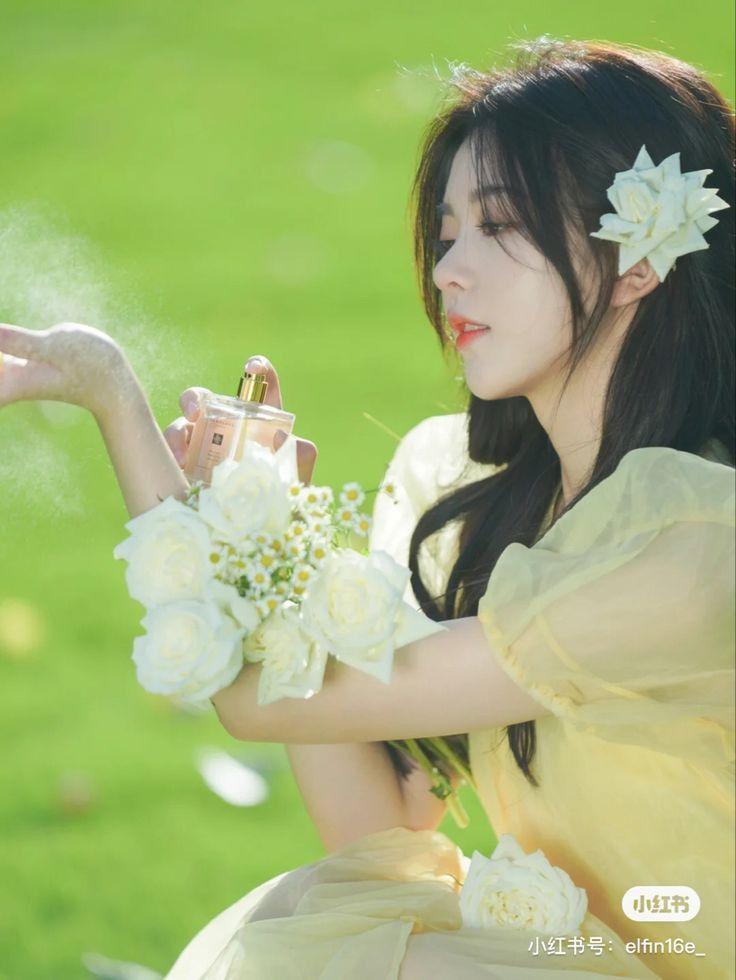 Ảnh gái xinh cầm hoa đẹp bên cạnh hoa
