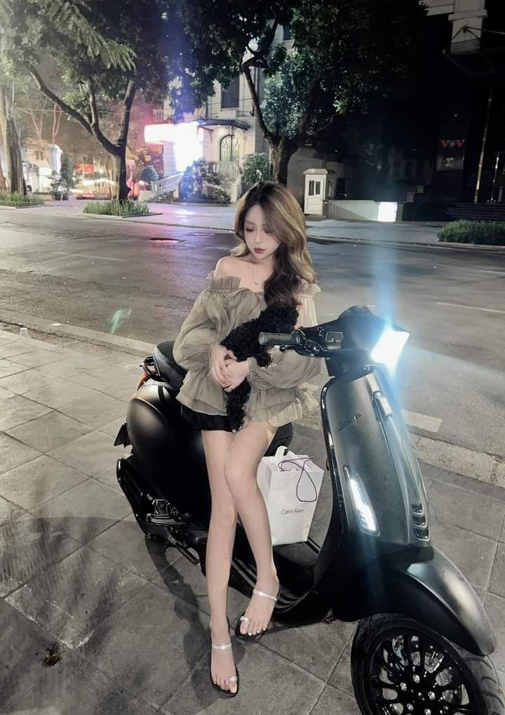 Gái xinh xinh com với ngực to trong thời trang xe tay ga đen