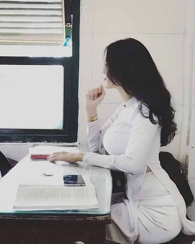 Ảnh cô gái xinh đẹp trong áo dài giữa vườn hoa
