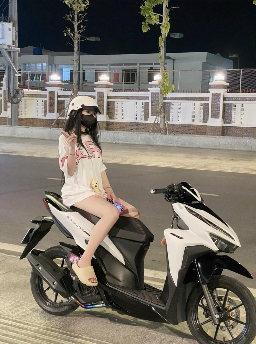 Gái xinh tóc ngắn mặc áo thun trắng trong vườn hoa