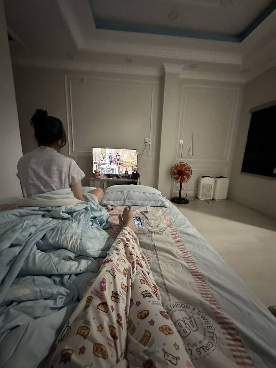 Cô gái xinh đẹp ngồi trên giường nghỉ trong phòng ngủ