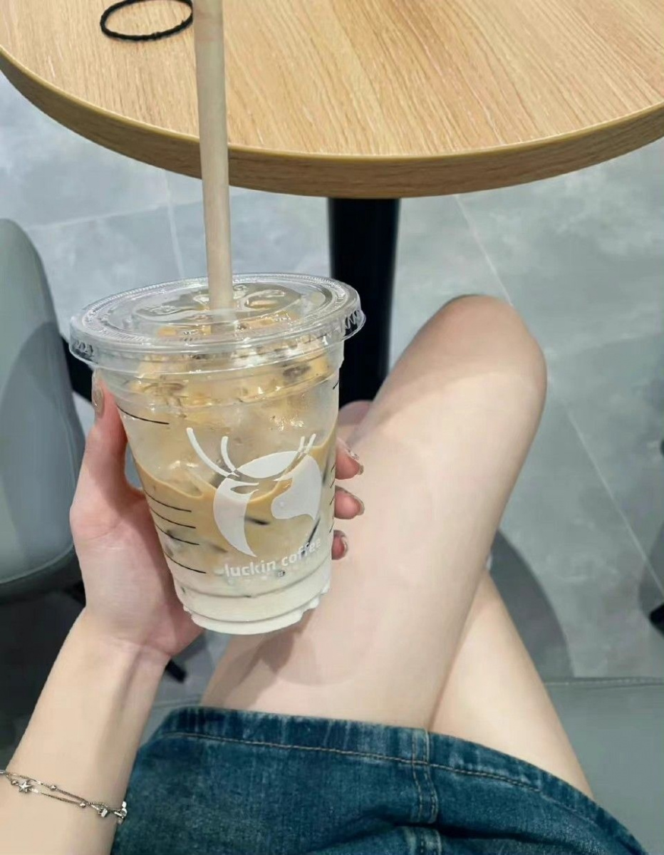 Cô gái xinh đẹp mặc áo vàng uống nước ép tại quán cafe
