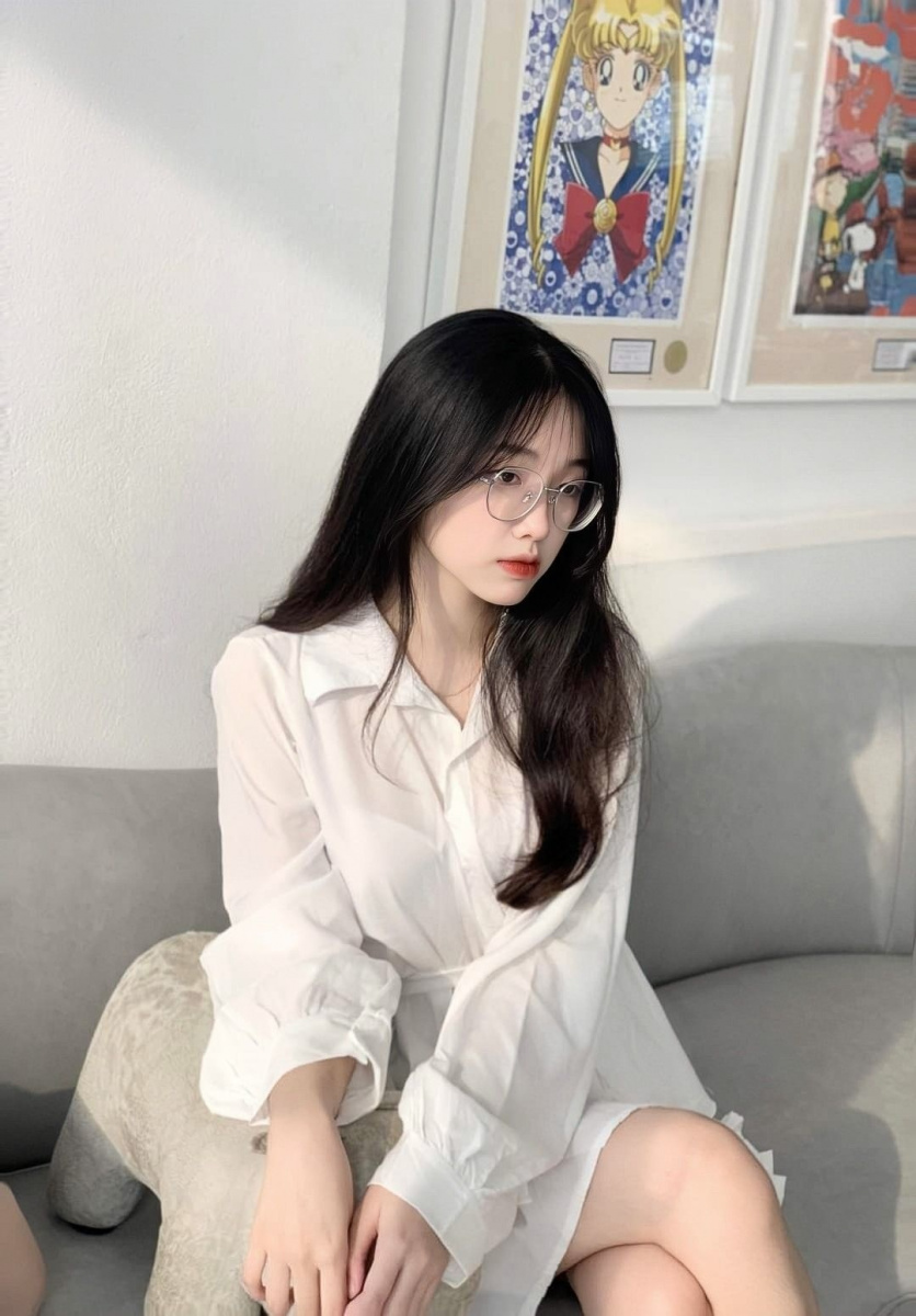 Cô gái xinh xắn tóc đen dài trong bộ áo ngồi duyên dáng