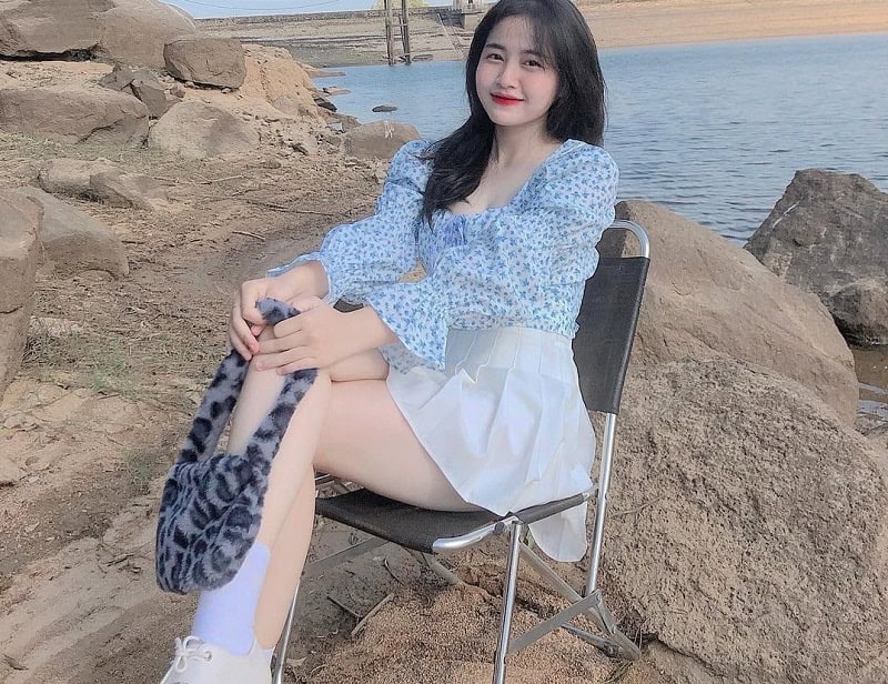 Ảnh gái mặc váy ngắn màu trắng ngồi trên bờ biển